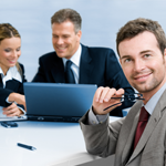 Photo of a manager smiling while employees work together